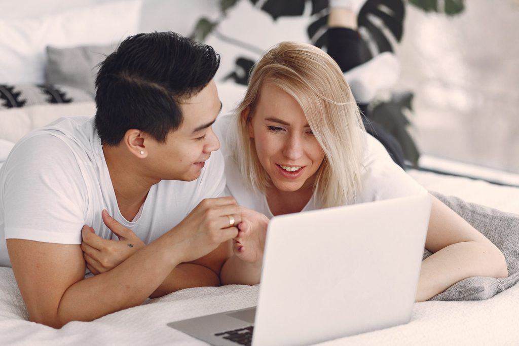 man-and-woman-on-bed-using-macbook-3912398